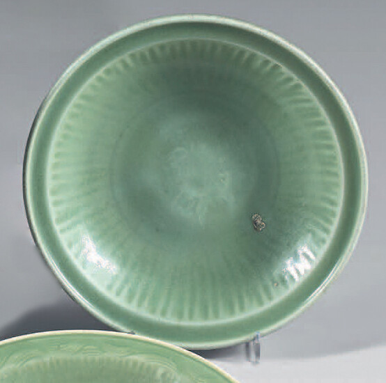 Chinese stoneware dish. Longquan, XV-XVIth century. Celadon enamelled circular shape with a gadrooned drop, engraved in the center of a flower, due to a lack of firing in the center.
