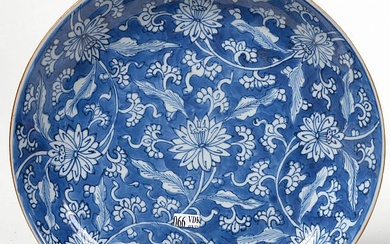 Grand plat rond en porcelaine bleue et blanche de Chine à décor de "Fleurs de lotus". Epoque: fin XVIIème - début XVIIIème. (Petits éclats). Diam.:+/-34,5cm.