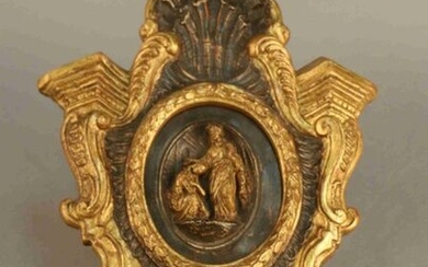 HIGH RELIEF oval wood carved of a baptism or blessing scene in a monoxyl frame carved with golden and silver scrolls, scales and shells.Italian work.