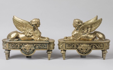 Paire de CHENETS en bronze doré à décor de sphinges couchées, ailes déployées, posant sur...