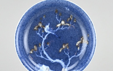 Plat en porcelaine de Chine à décor d'oiseau sur un arbre en fleurs. Marque inférieure...