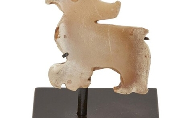 Property of a Gentleman (Lots 55-80) A Chinese celadon jade 'bird' pendant, late Shang/early Western Zhou dynasty, carved with crested head and sharp beak, the celadon stone with calcified patches to the edges, 3.5x3.5cm, later metal stand...