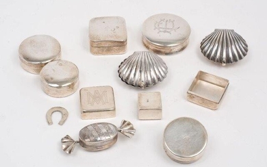 Ten silver and white metal trinket and pill boxes, all stamped 925, the group including one box designed as a wrapped sweet, London, 1999, Ari D Norman, 6.3cm long; a Greek example with applied teddy bear to lid, and two designed as scallop shells...