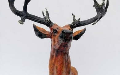 Large bronze statue of a red deer on a pedestal