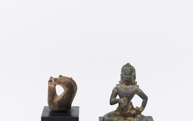 A carved schist seated figure of Vajrasattva together with a carved stone hand