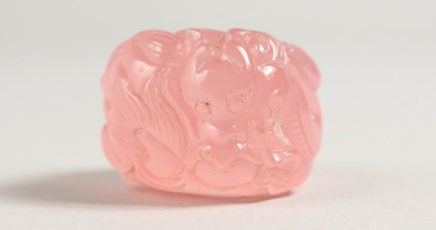 A CHINESE CARVED PINK QUARTZ RING.