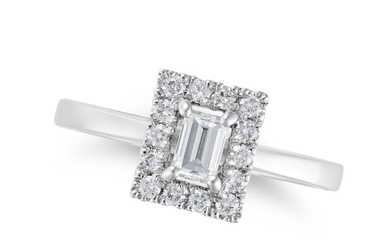 A DIAMOND RING in platinum, set with a baguette cut diamond in a border of round brilliant cut