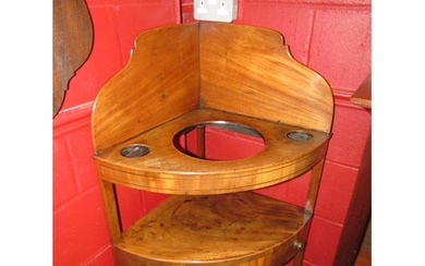 A George III flame mahogany three tier corner washstand, the...