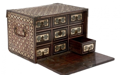 A Mughal ivory-inlaid wooden chest, Northwest India, 17th century, of rectangular form with fall front revealing six drawers with applied openwork polychrome lattice panels surrounded by borders of inlaid ivory rosettes, large central drawer with...