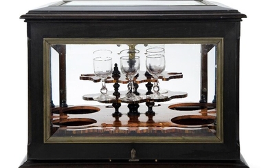 A Napoleon III ebonised liqueur cabinet, probably by Paul Sormani, third quarter 19th century, the hinged cover and sides enclosing a lift-out calamander stand with gilt-bronze carrying handle, with four later glasses, the lockplate etched Rue...