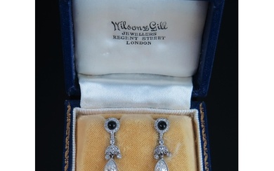 A Pair of Diamond and Onyx Drop Pendant Earrings in a platin...