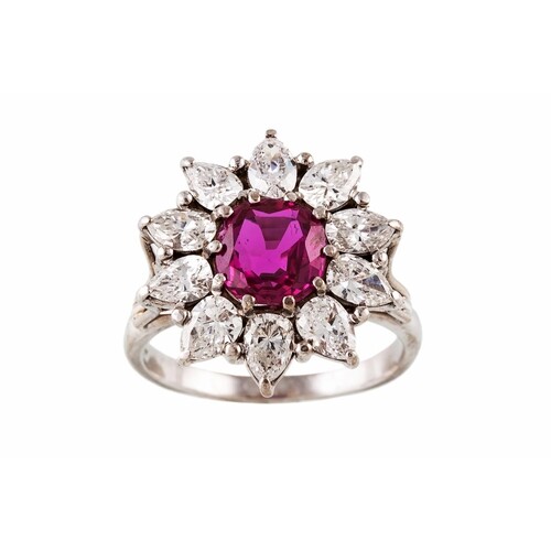 A RUBY AND DIAMOND CLUSTER RING, the cushion cut ruby to a m...