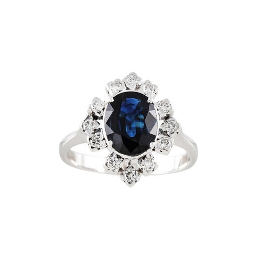 A SAPPHIRE AND DIAMOND CLUSTER RING, the oval sapphire to br...