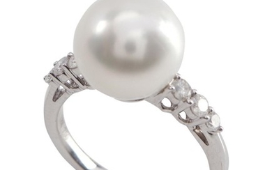 A SOUTH SEA PEARL AND DIAMOND RING - Featuring a round pearl of silver white hues, measuring 11.5mm, flanked by round brilliant cut...