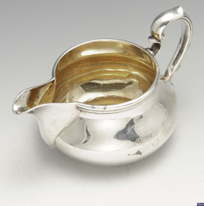 A Victorian silver cream jug by Garrard, bearing the royal cypher for Queen Victoria.