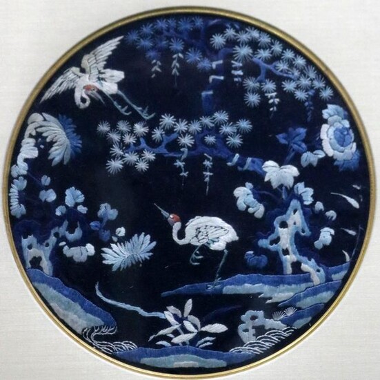 A framed oval Chinese blue ground crane embroidery