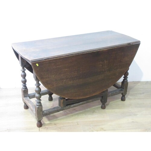 A large antique oak Gateleg Table with oval top on bobbin tu...