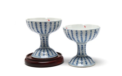A pair of blue and white porcelain wine glasses painted with Chinese characters