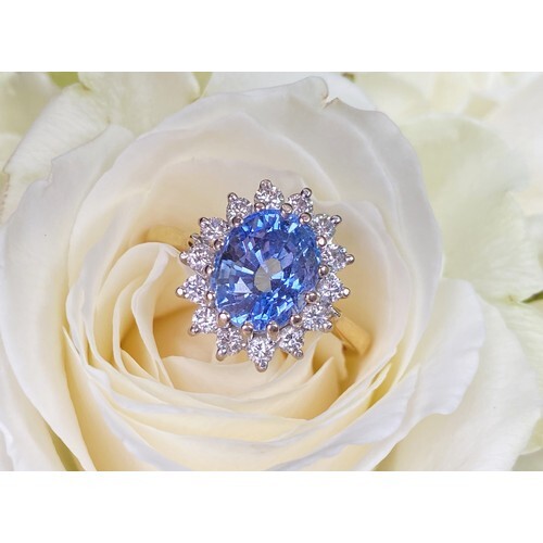 A sapphire and diamond cluster ring, the central oval mixed ...