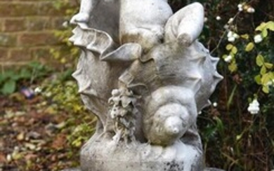 A sculpted marble figure group of a winged putto climbing from a conch shell