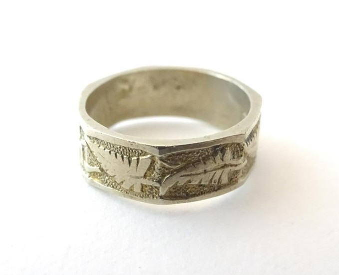 A white metal ring with foliate decoration. Marked '15'