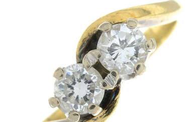 An 18ct gold brilliant-cut diamond two-stone crossover ring.