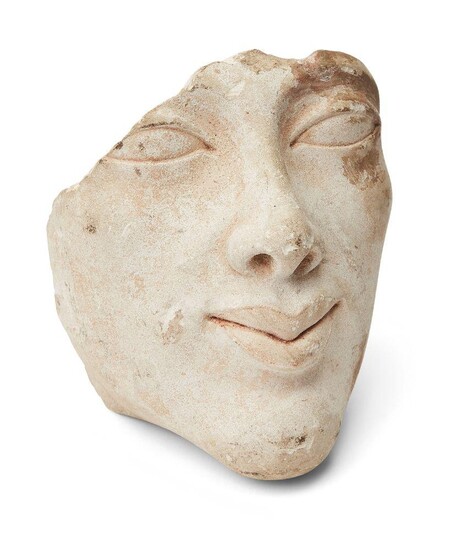 An Egyptian style limestone head of Amenhotep IV (Akhenaten) with elliptical eyes, cosmetic lines remaining on one eye and exaggerated lips with traces of pink slip remaining, the top and back missing, Not Ancient, 10.5cm high Provenance: Formerly...