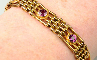 An early 20th century 9ct gold gate-link bracelet, with purple garnet spacers.