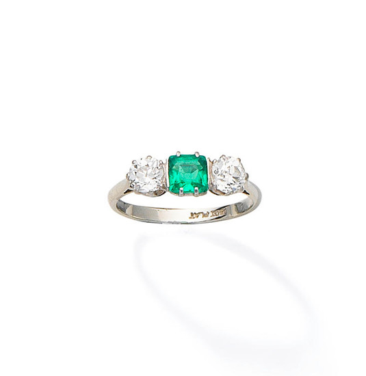 An emerald and diamond three-stone ring