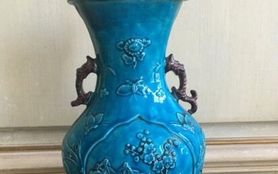 Blue enamelled porcelain vase, with flattened belly, plum tree branch decoration in relief. China. XIXth
