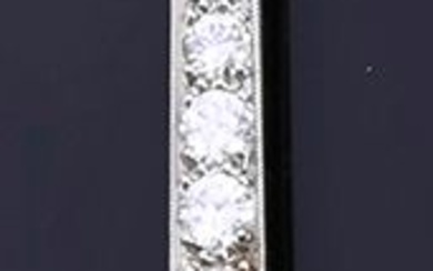 Broche barrette en or 18k (750e) et platine, ornée d'une chute de diamants taille brillant...
