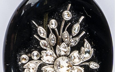 Broche souvenir ovale en onyx à décor d’un bouquet de fleurs sur argent (800 millièmes)...
