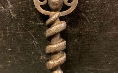 Carved wrought iron key, the ring featuring a Janus head, the stem decorated with a snake in relief. Early 18th century.