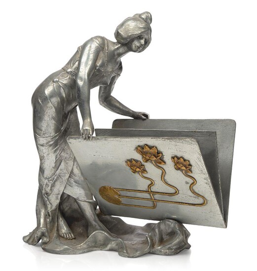 Elsie Ward Hering (American 1872-1923), a Spelter and bronze figural letter holder, c.1900, signed Hering, Modelled and cast as an art nouveau maiden leaning over the letter holder which is embellished on one side with lilies on sinuous stems and a...
