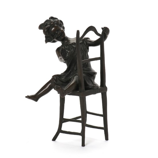 Franz Iffland: A patinated bronze figure of a girl on a chair. Signed. H. 22 cm.