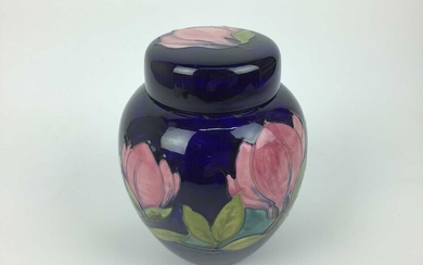 Moorcroft pottery ginger jar and cover decorated in the Magnolia pattern on blue ground, impressed marks and green painted signature to base, 20.5cm high