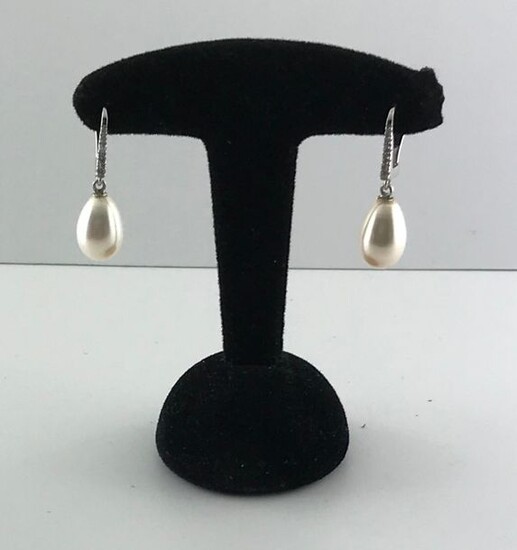 Pair of 750°/°°° white gold sleepers set with a line of diamonds holding a pear-shaped freshwater cultured pearl in pendants, Gross weight: 4,02g
