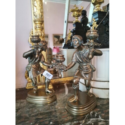Pair of brass candlesticks in the form of serving figures. {...