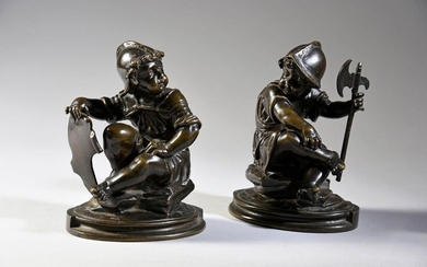 Pair of statuettes of putti symbolizing war in patinated bronze, they are represented sitting on rocks, wearing helmets and carrying a breastplate, holding a shield or an axe.