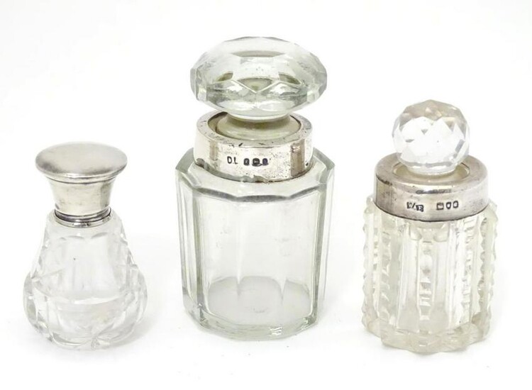 Three glass scent bottles with silver lids/collars.