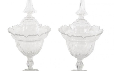 A pair of faceted glass jars and domed covers