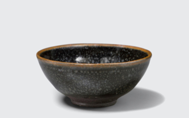 A small black glazed bowl with metallic 'oil spot' decoration