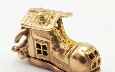 A 9 K yellow gold charm in the shape of a boot that opens to...