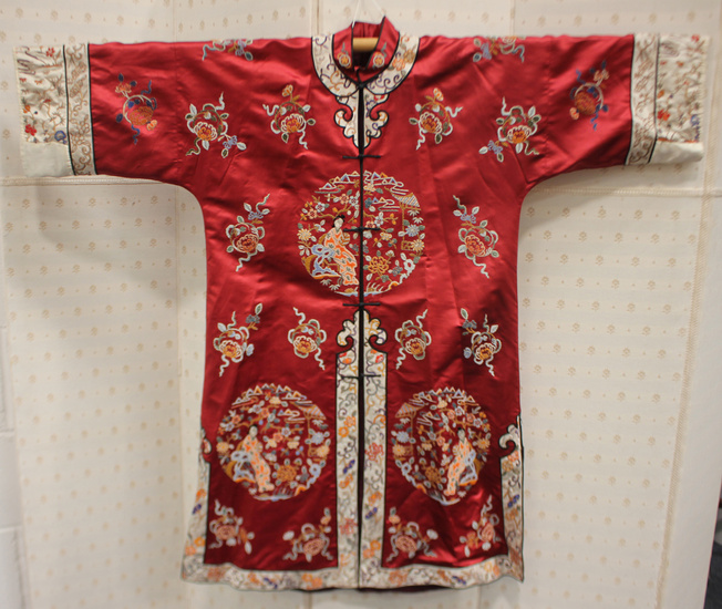 A Chinese red silk embroidered coat/robe, 20th century, worked in coloured threads with figure and f