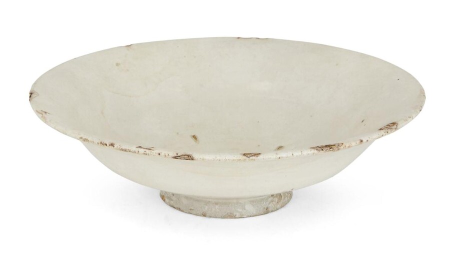 A Chinese stoneware Cizhou-type white-glazed bowl, Northern Song dynasty, on short foot with curving sides that rise to an everted rim, covered in white slip under a clear glaze, 18.5cm diameter