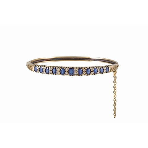 A DIAMOND AND SAPPHIRE BANGLE, the sapphires set between dia...