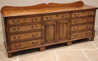 A George III honey oak and mahogany crossbanded dresser base...