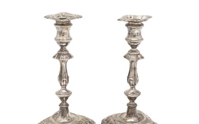 A PAIR OF EDWARDIAN SILVER CANDLESTICKS. on shaped square ba...