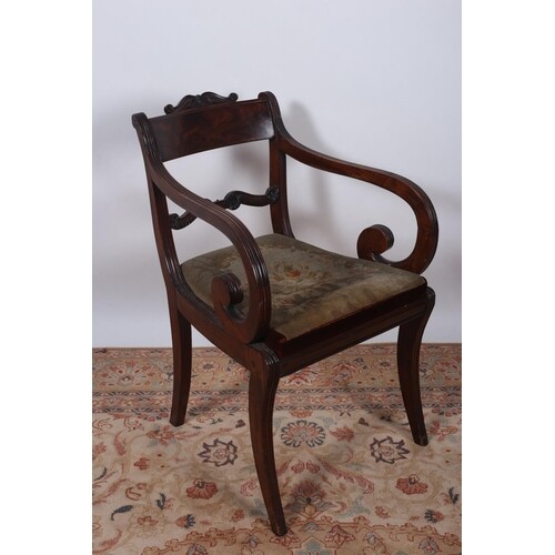A REGENCY MAHOGANY ELBOW CHAIR the curved top rail with carv...