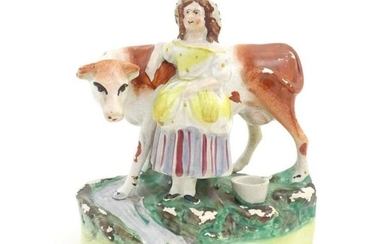 A Staffordshire pottery model of a cow with a milkmaid